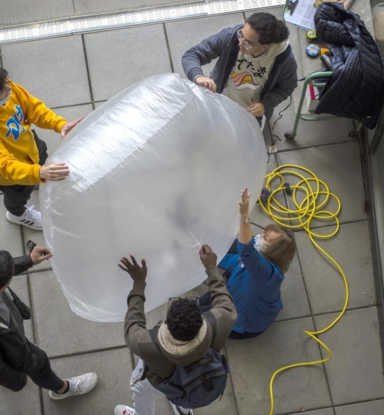Students blow up a homemade balloon
