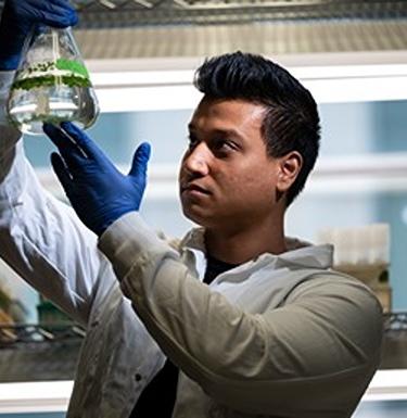 Scientist holds up a beaker with liquid in it