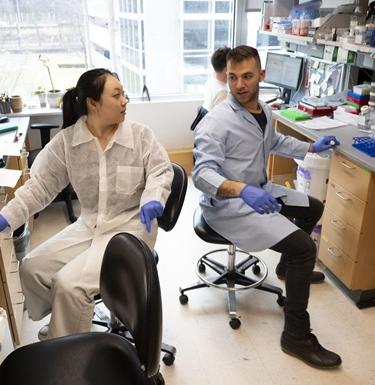 Two students talk in a science lab