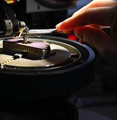 Scientist works on a microchip under a focused light