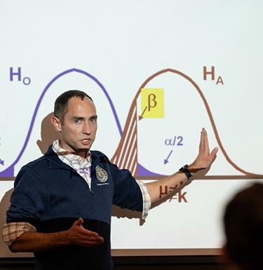 Professor teaching in front of a projector